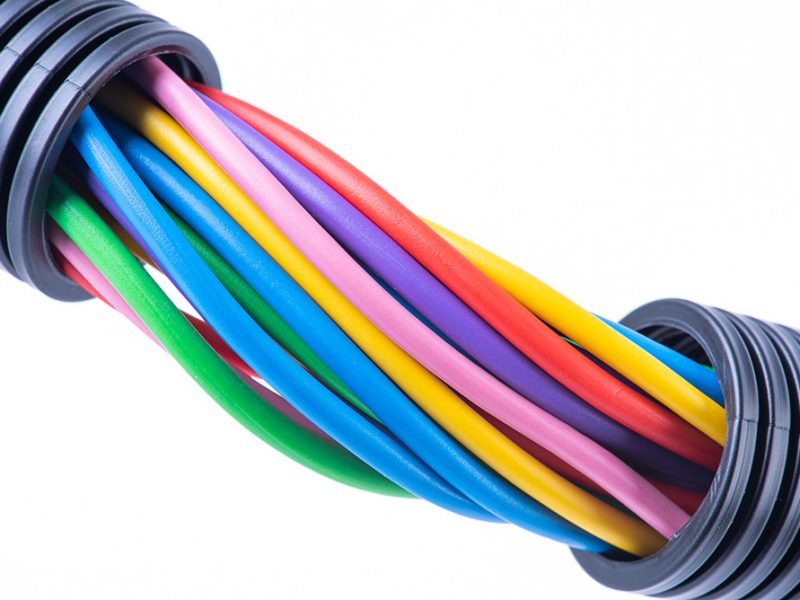 Colorful electrical cables in protective corrugated pipe isolated on white background